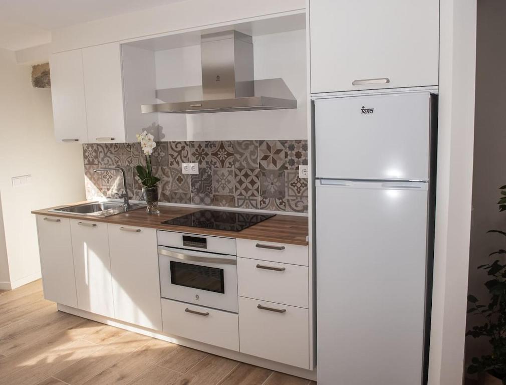Segunda vista de la cocina mostrando encimera, cafetera y detalle del equipamiento completo
